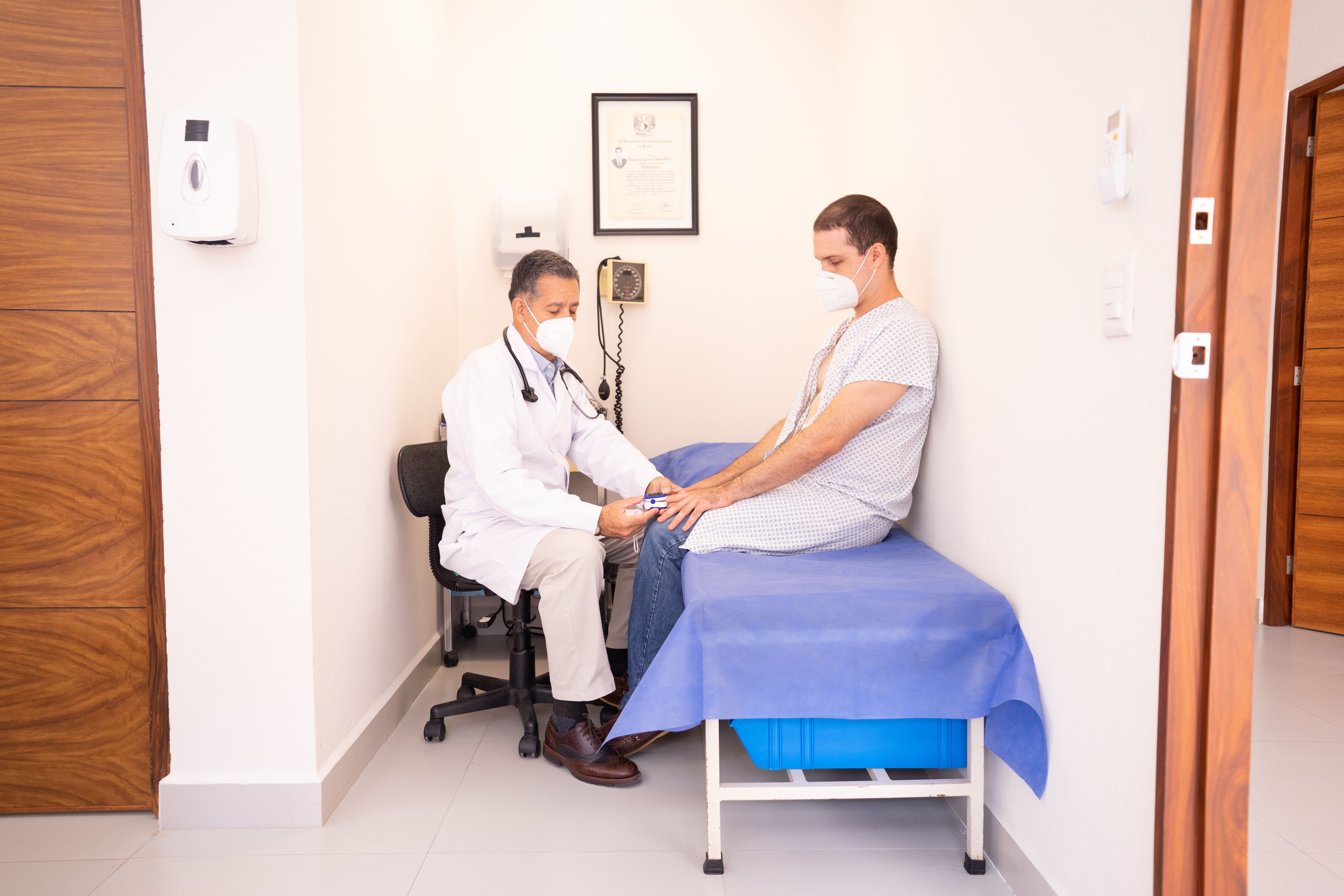 Doctor checking a patient's vitals in a clinical setting during a health consultation.