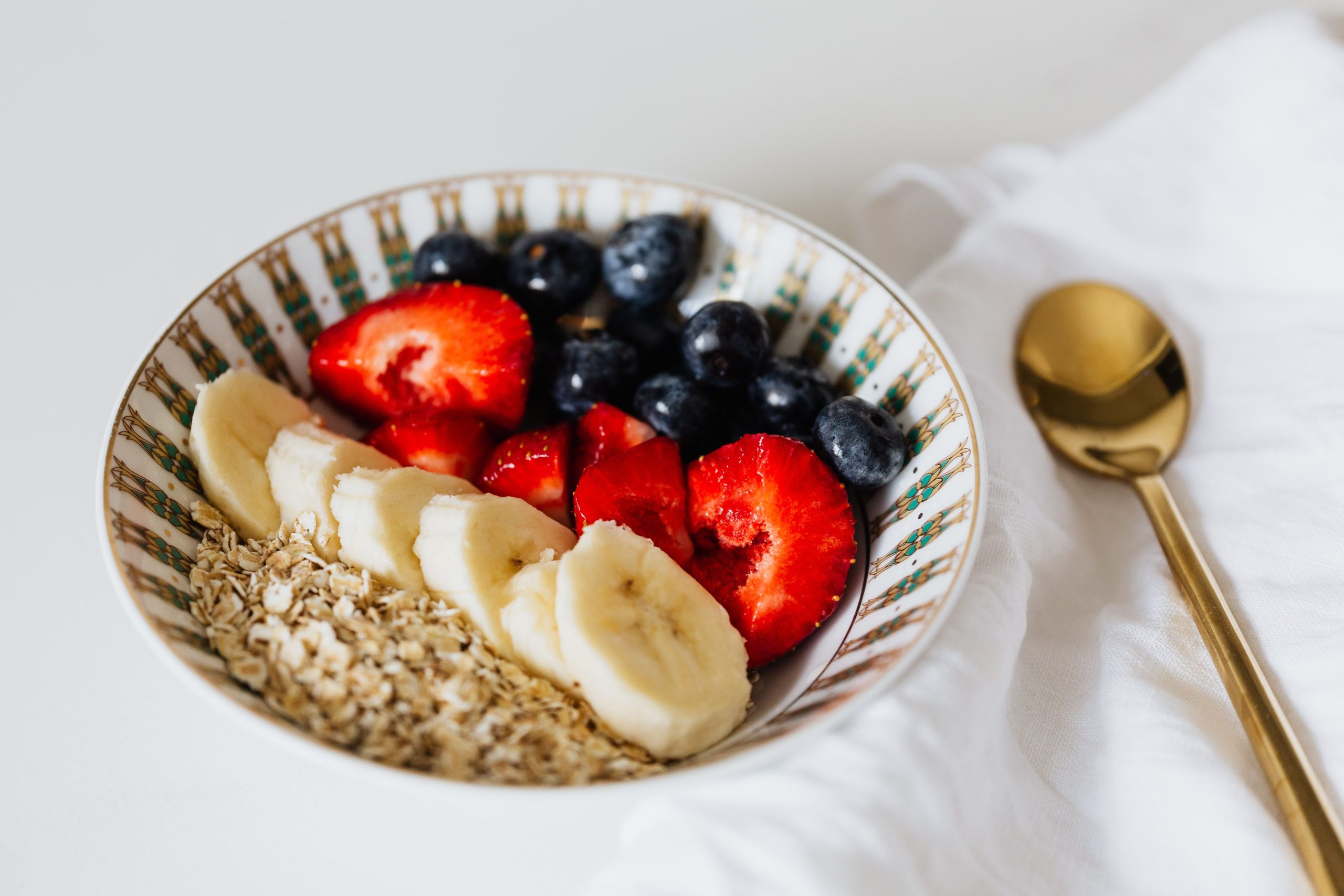 Building a Weight-Management Plan Around Your Health A vibrant bowl of oats with sliced bananas, strawberries, and blueberries, ideal for a healthy breakfast.